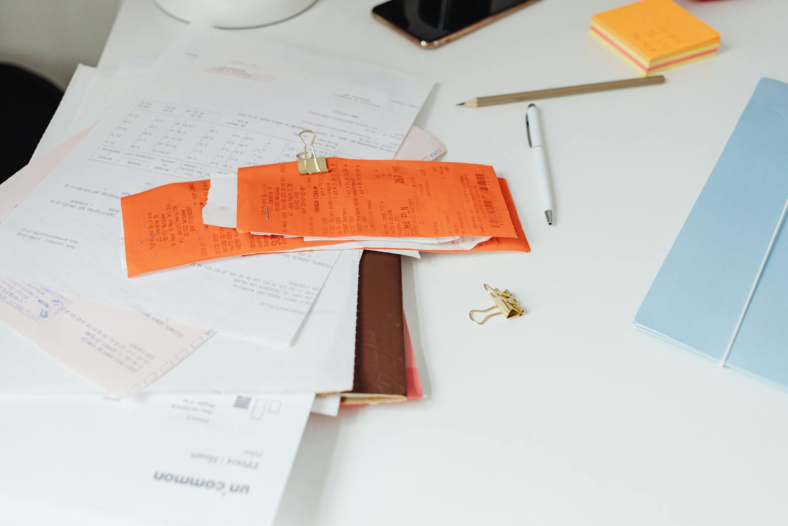 A desk with receipts and stationery — doing mobile mechanic paperwork on a computer