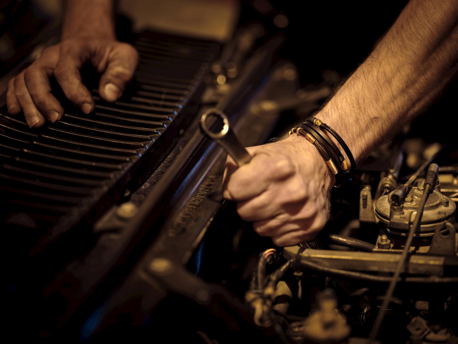 Mechanic hands tightening a bolt — comparing mobile mechanic software